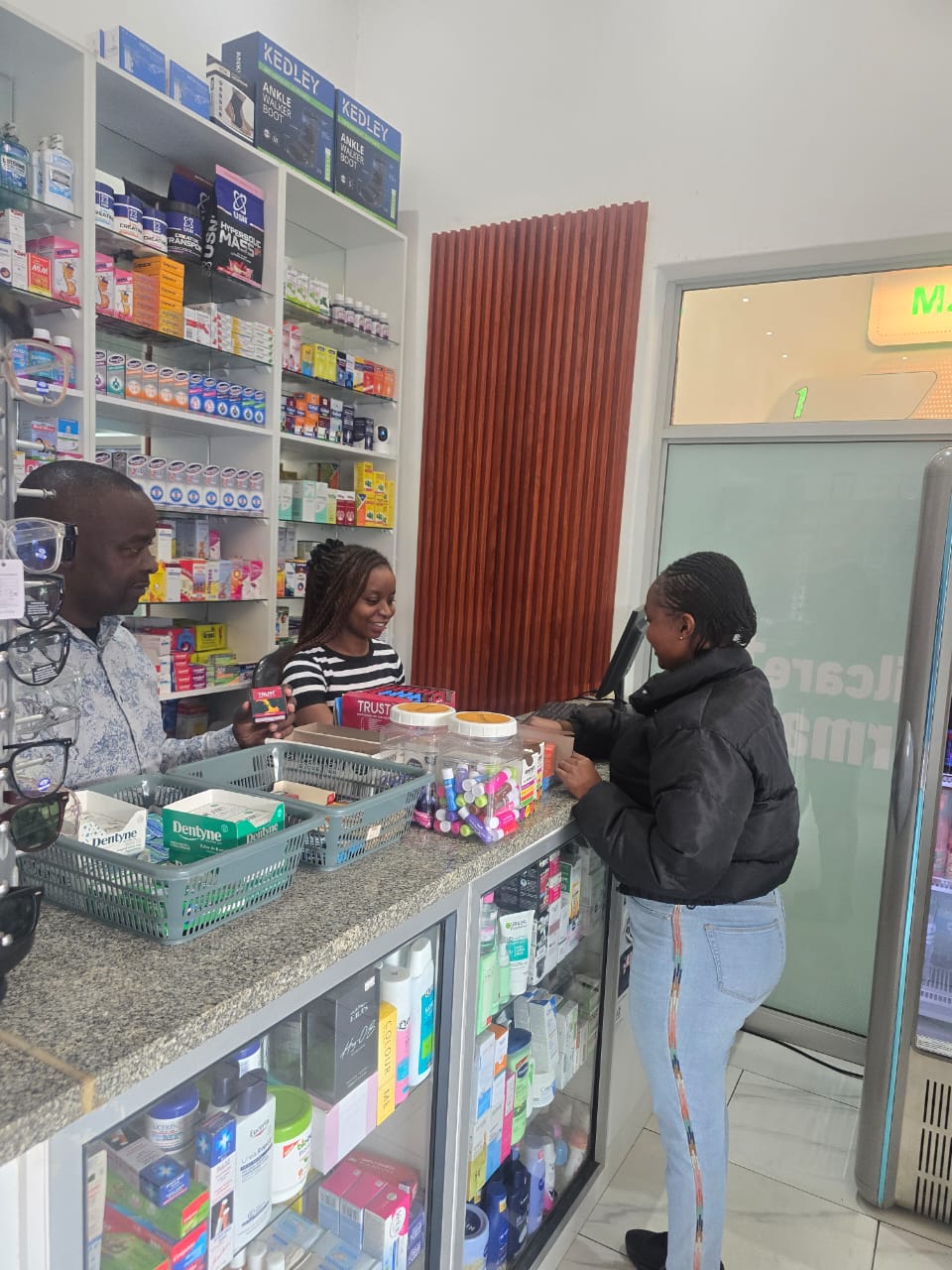 Wilcare Pharmacy interior — friendly pharmacists serving a customer
